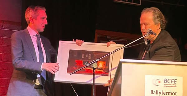 Minister Simon Harris is presented with an original art piece created by a BCFE student